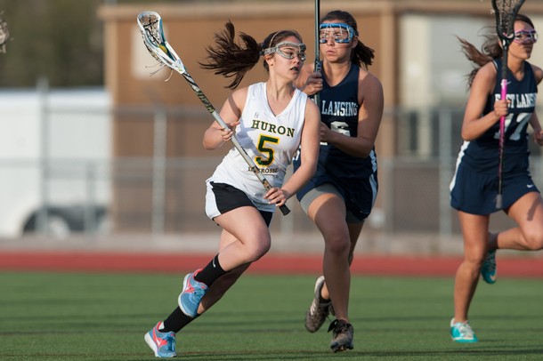 Huron's Mariel Ward cradles the ball as she drives down field during the first half of Huron's game against East Lansing on Thursday, May 2.
Courtney Sacco I AnnArbor.com   